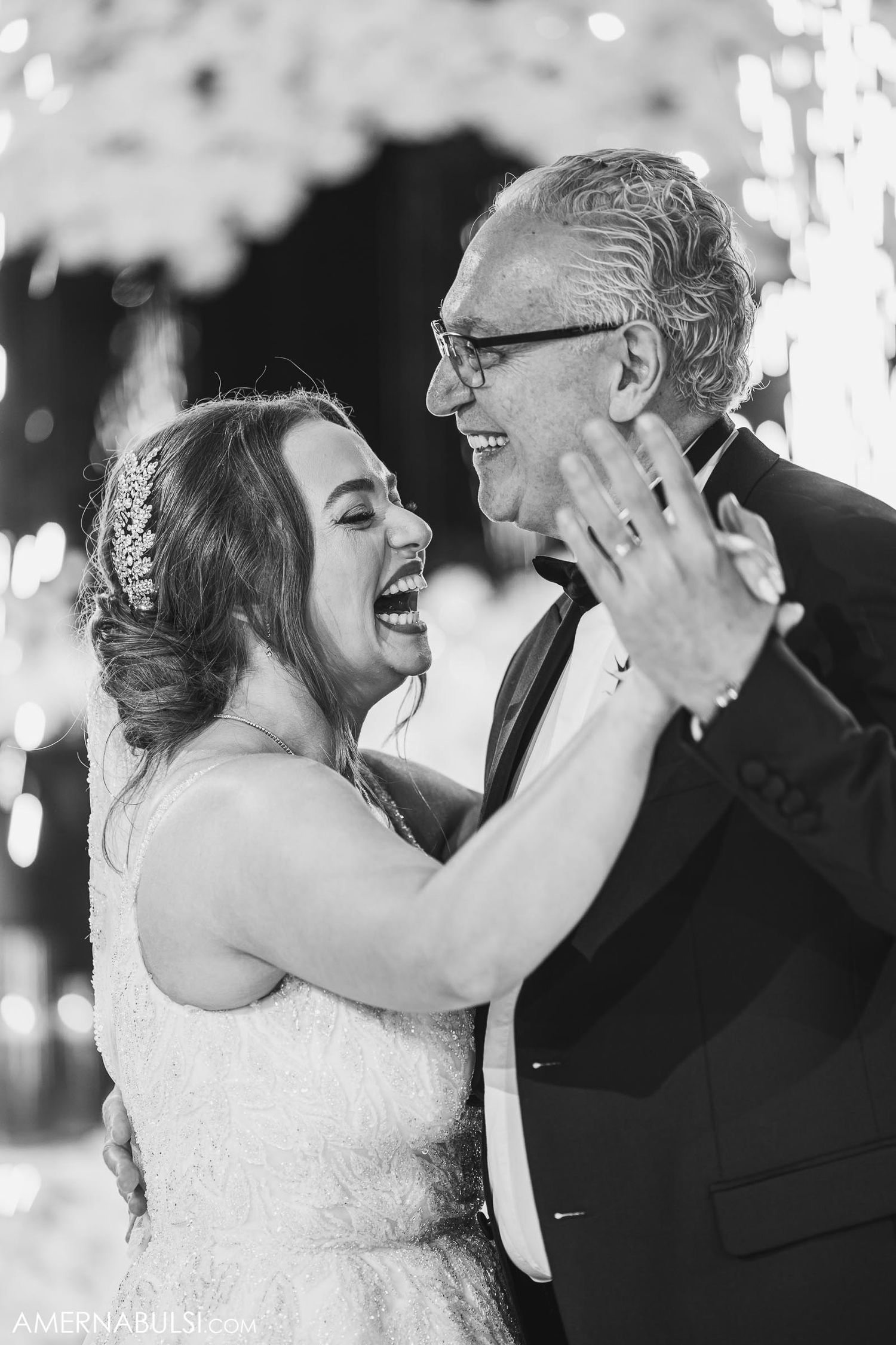 A heartwarming dance moment captured in black and white with sparklers in the background.