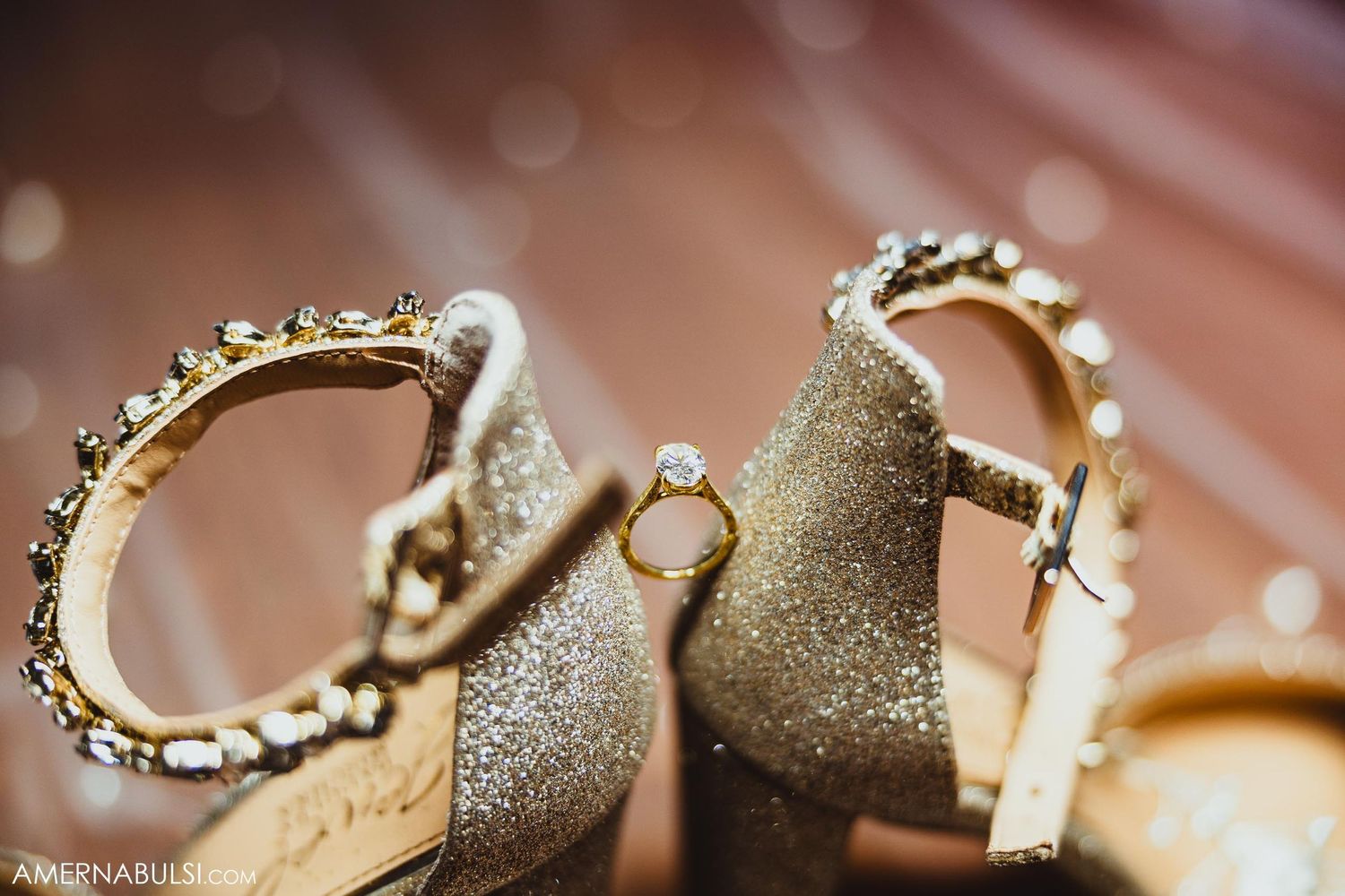 Close up of elegant gold and silver wedding rings with sparkly details on a textured surface.