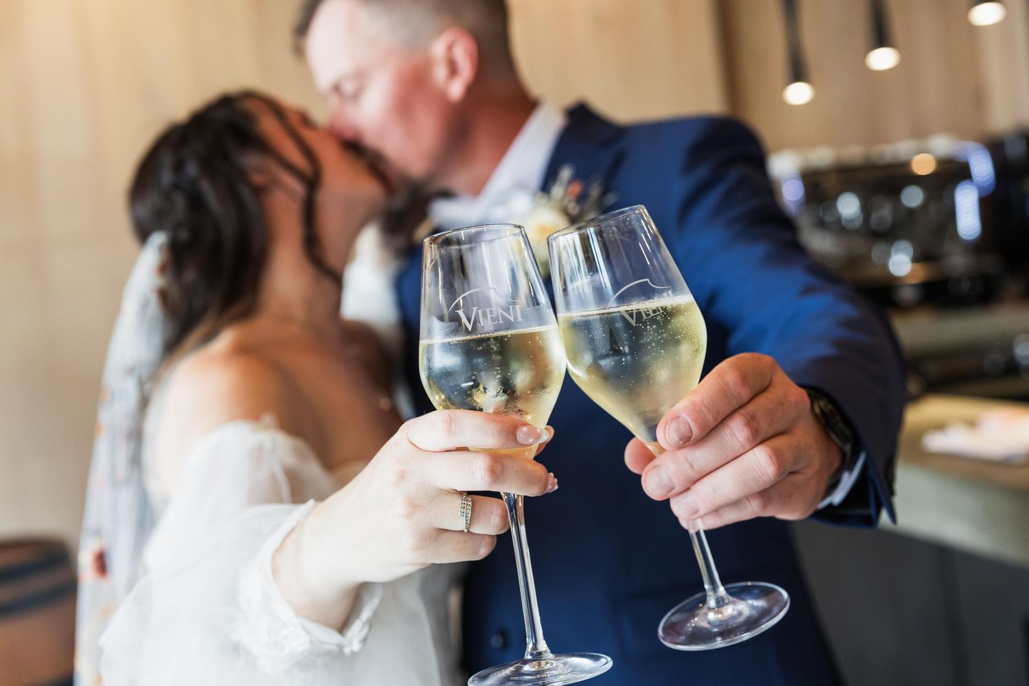 A couple toasts with white wine glasses during an intimate celebration moment.