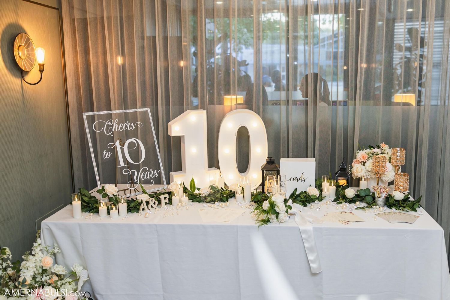 Wedding reception table number 10 display with white floral decorations and signage.
