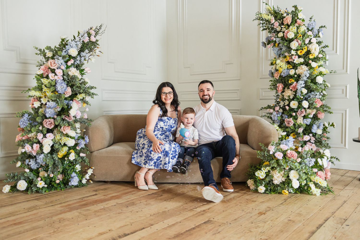 Family portrait session with floral arrangements in elegant indoor setting.