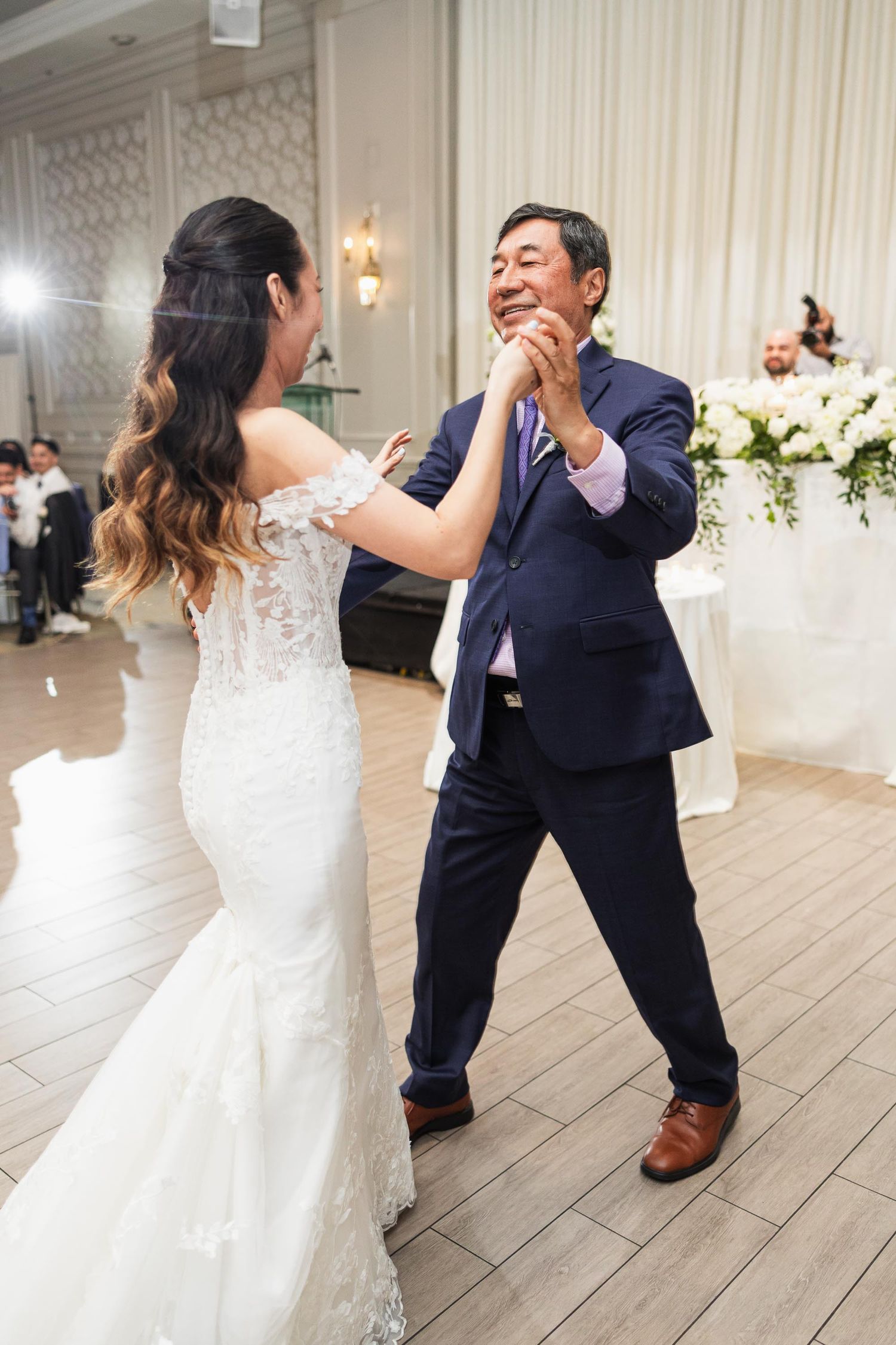 A bride and guest share an energetic dance moment on the wedding reception floor.