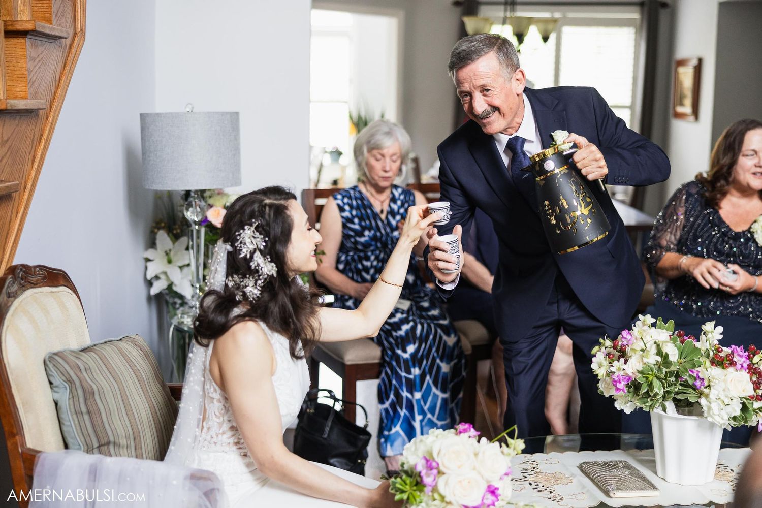 Group toasting and celebrating at a formal gathering with wine glasses and floral centerpieces.