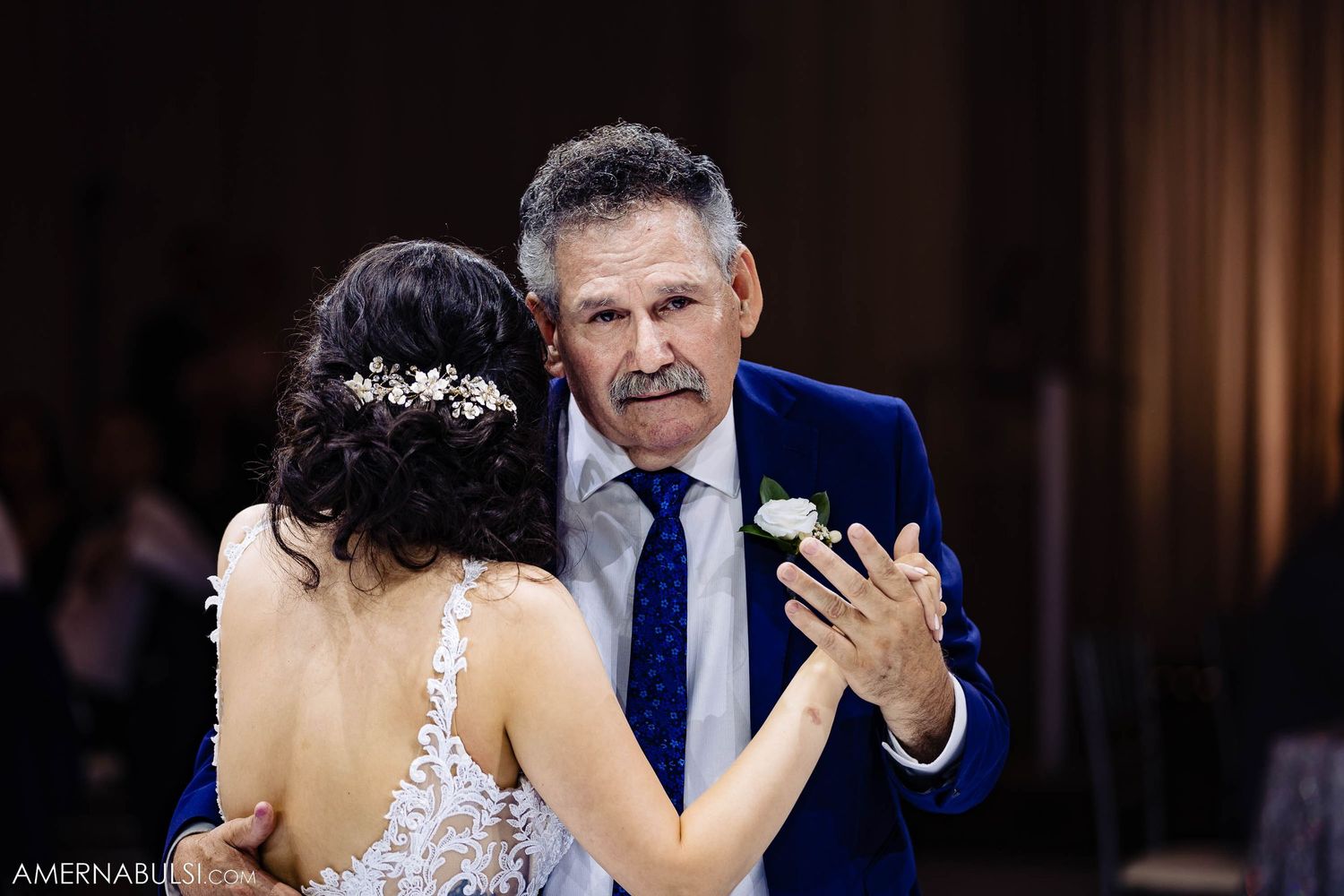 A tender moment between two dancers sharing an emotional dance at a formal event.