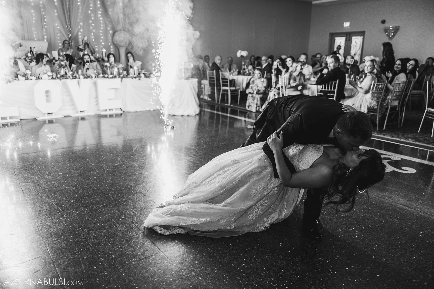 Black and white photo of dramatic wedding dance dip with sparkler effects.
