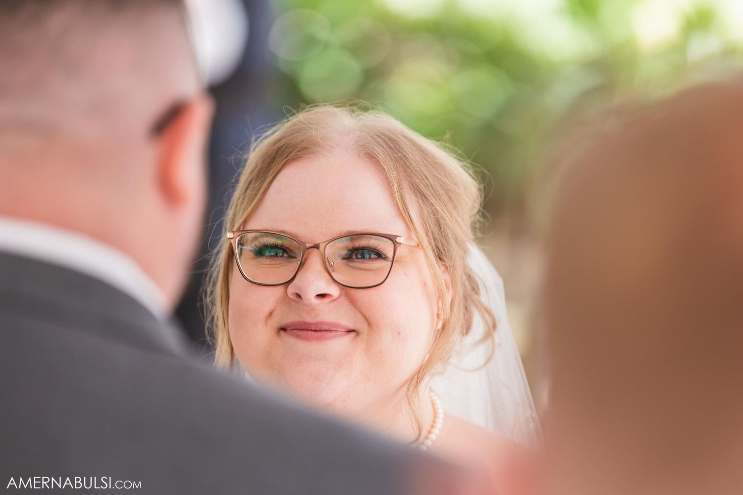 An intimate moment captured during a wedding ceremony under a white tent.