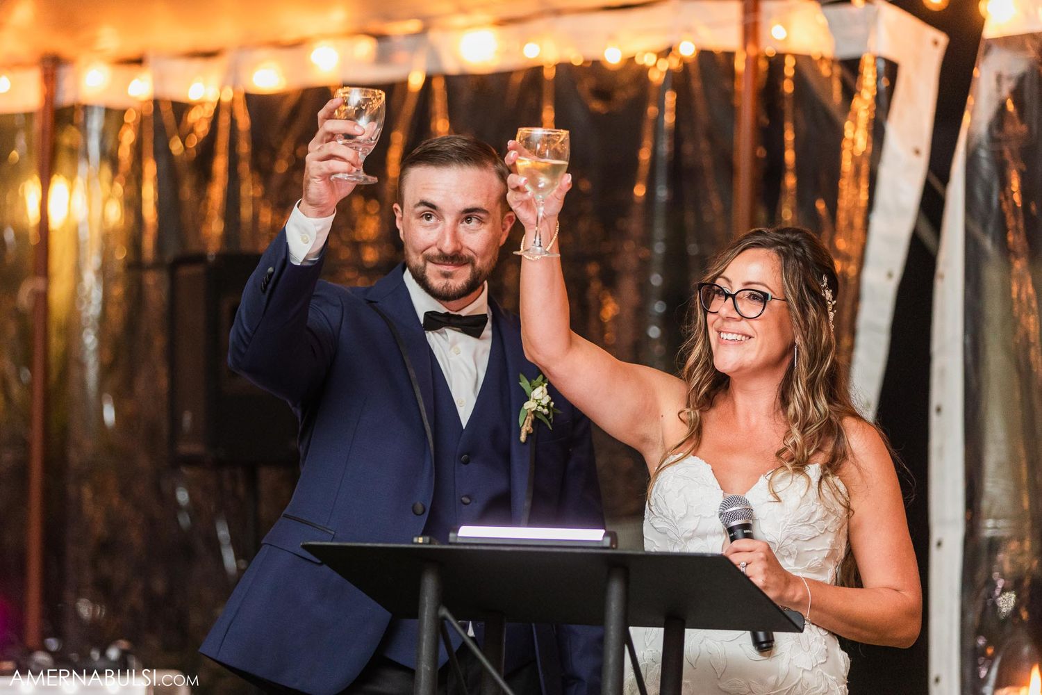 Couple raising their glasses in a celebratory toast during wedding speeches.