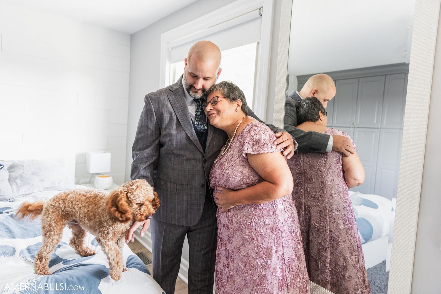 A wedding party gets ready in a bright bedroom with a fluffy brown dog joining the preparations.