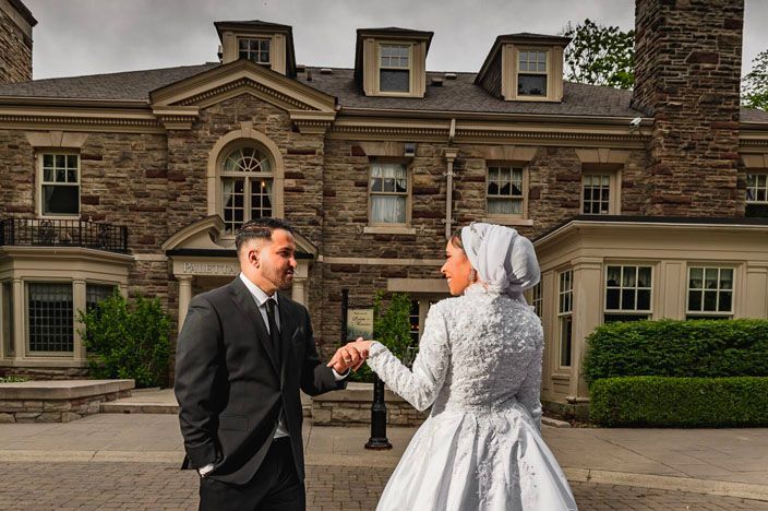 Elegant stone mansion provides classic backdrop for formal wedding photography.