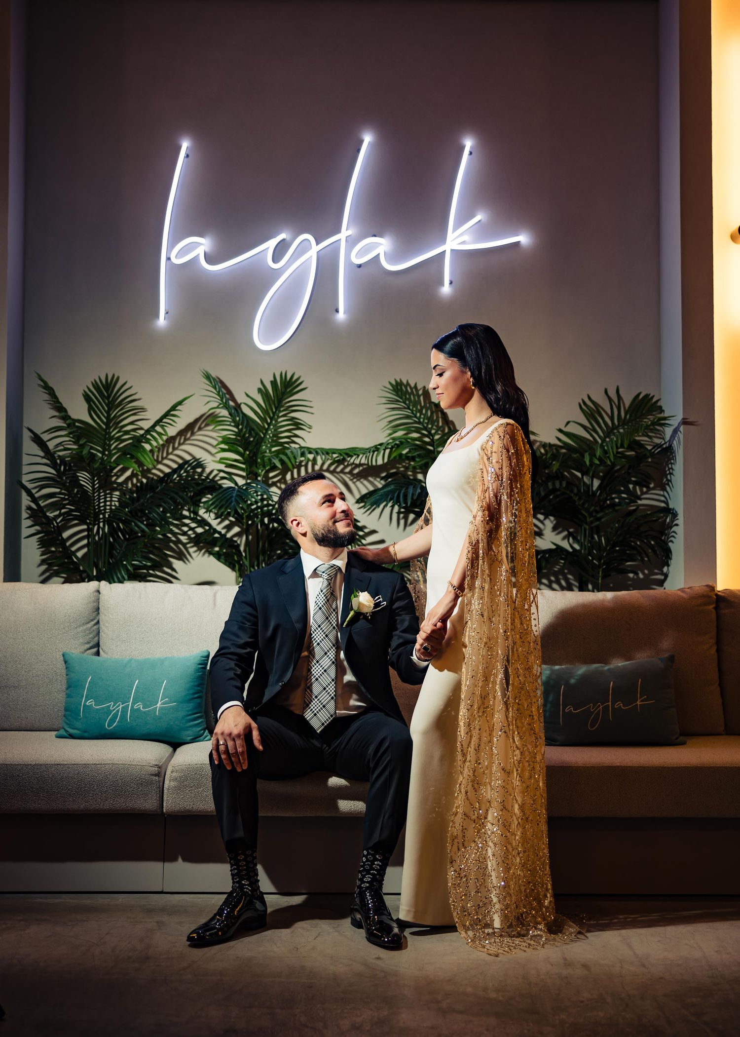 Glamorous wedding setup with neon sign reading 'laglak' and tropical palm decor.