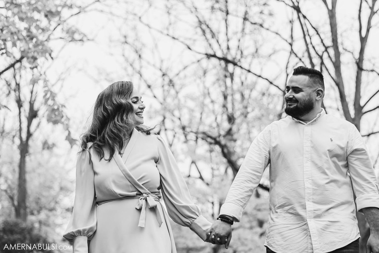 A black and white candid moment of a couple laughing during their engagement session.