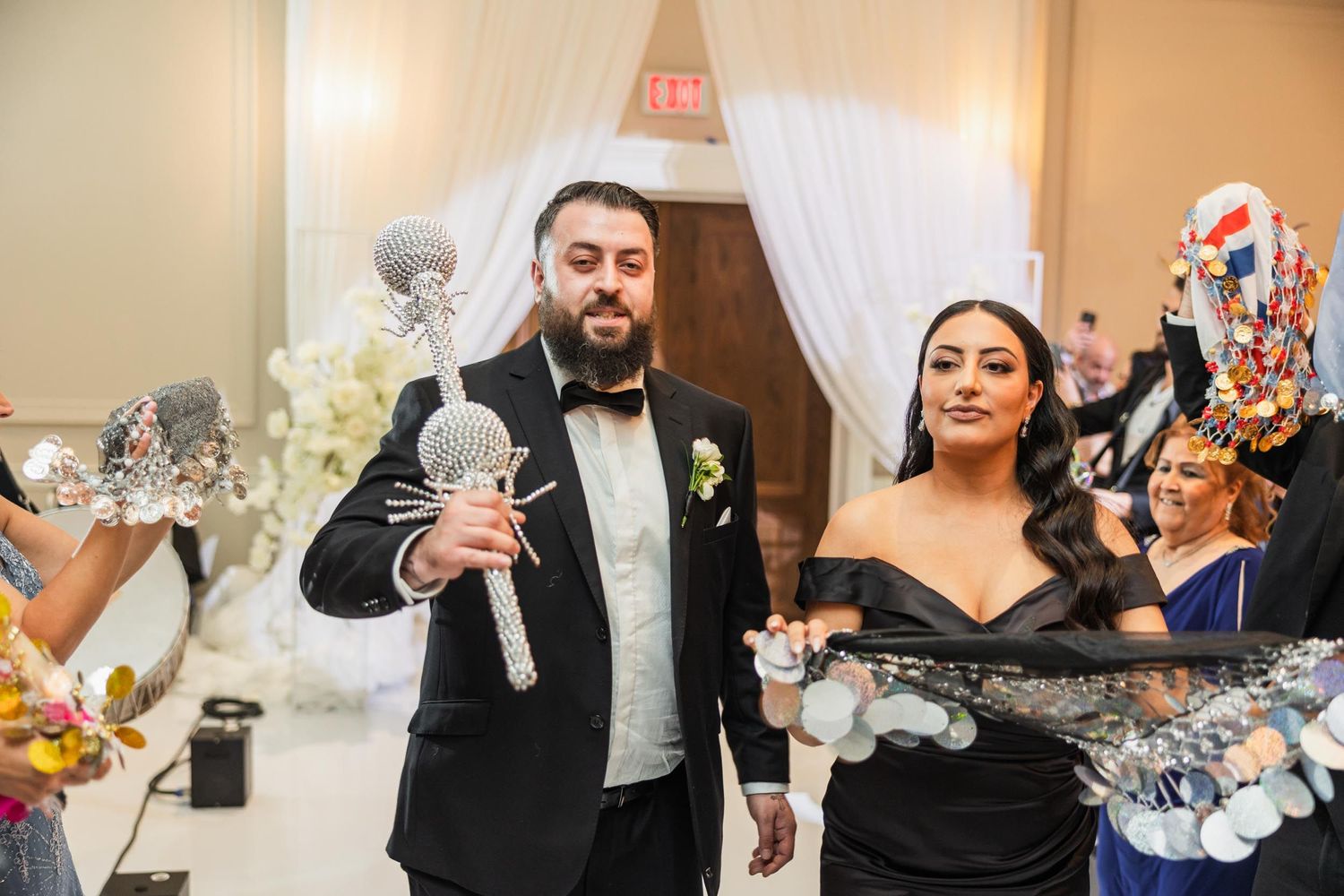 Reception celebration with guests holding festive party poppers and silver decorations.