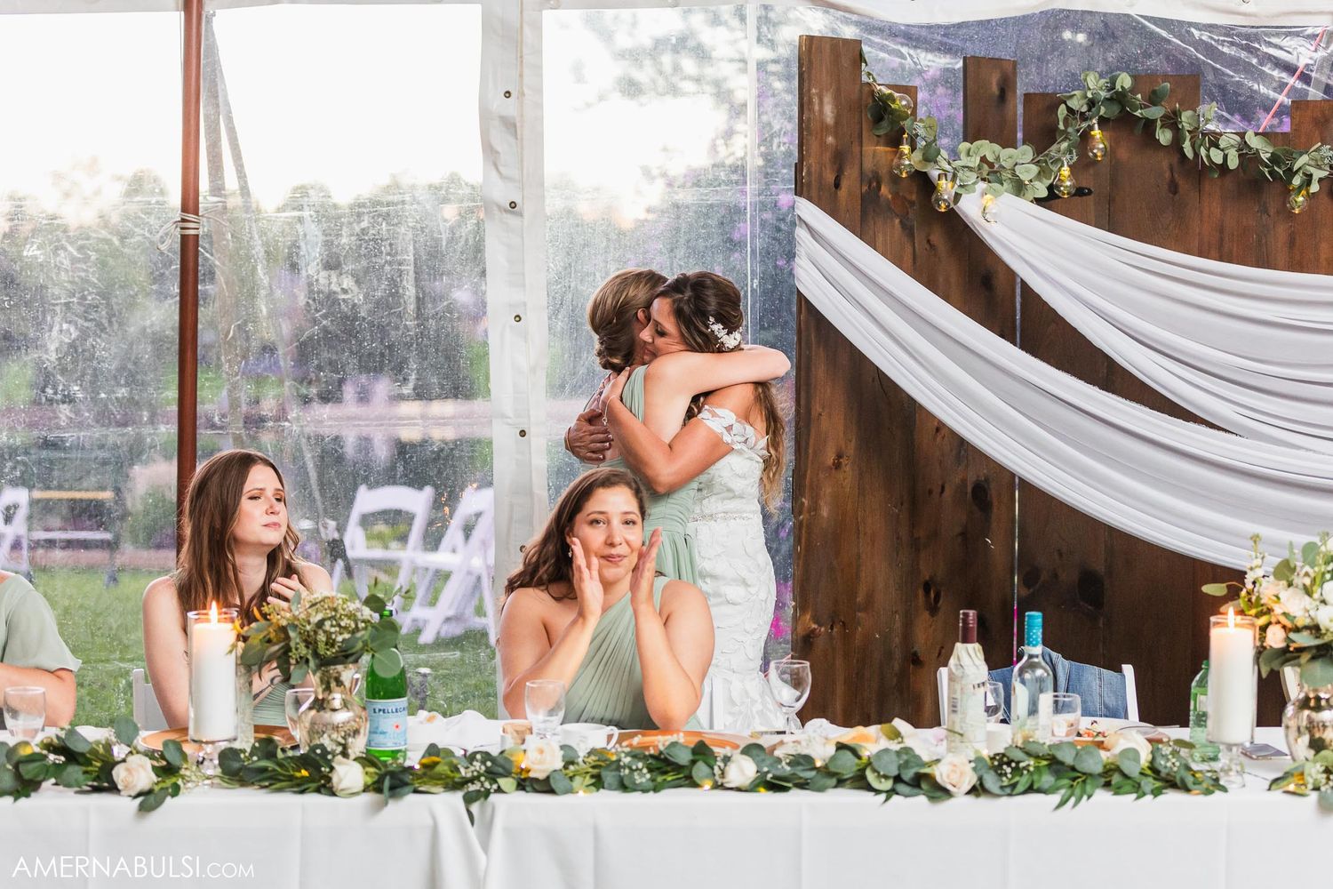 Wedding party members react emotionally at the head table during reception speeches.