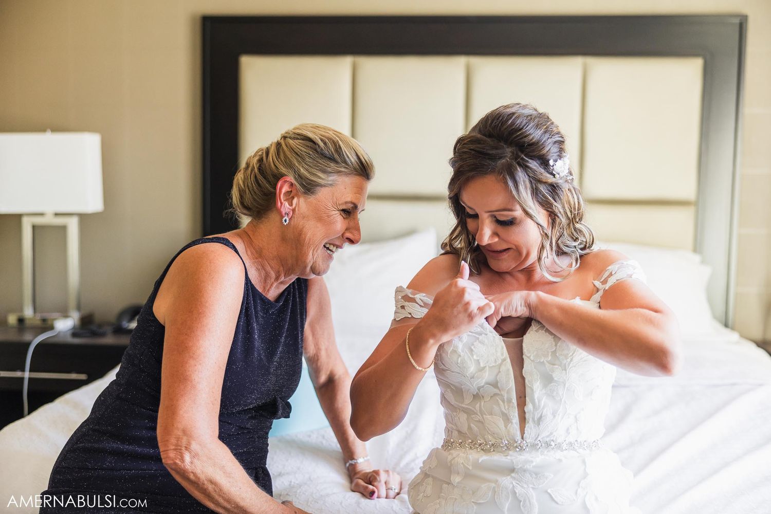 Two people share an emotional moment during wedding preparations in a hotel room.