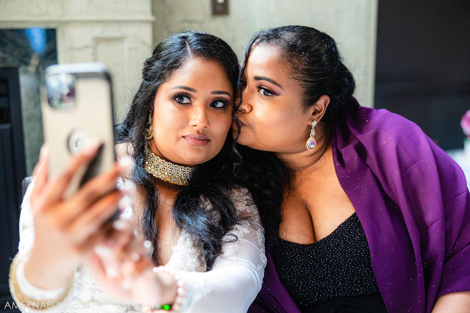 Two friends taking a selfie at a formal celebration.