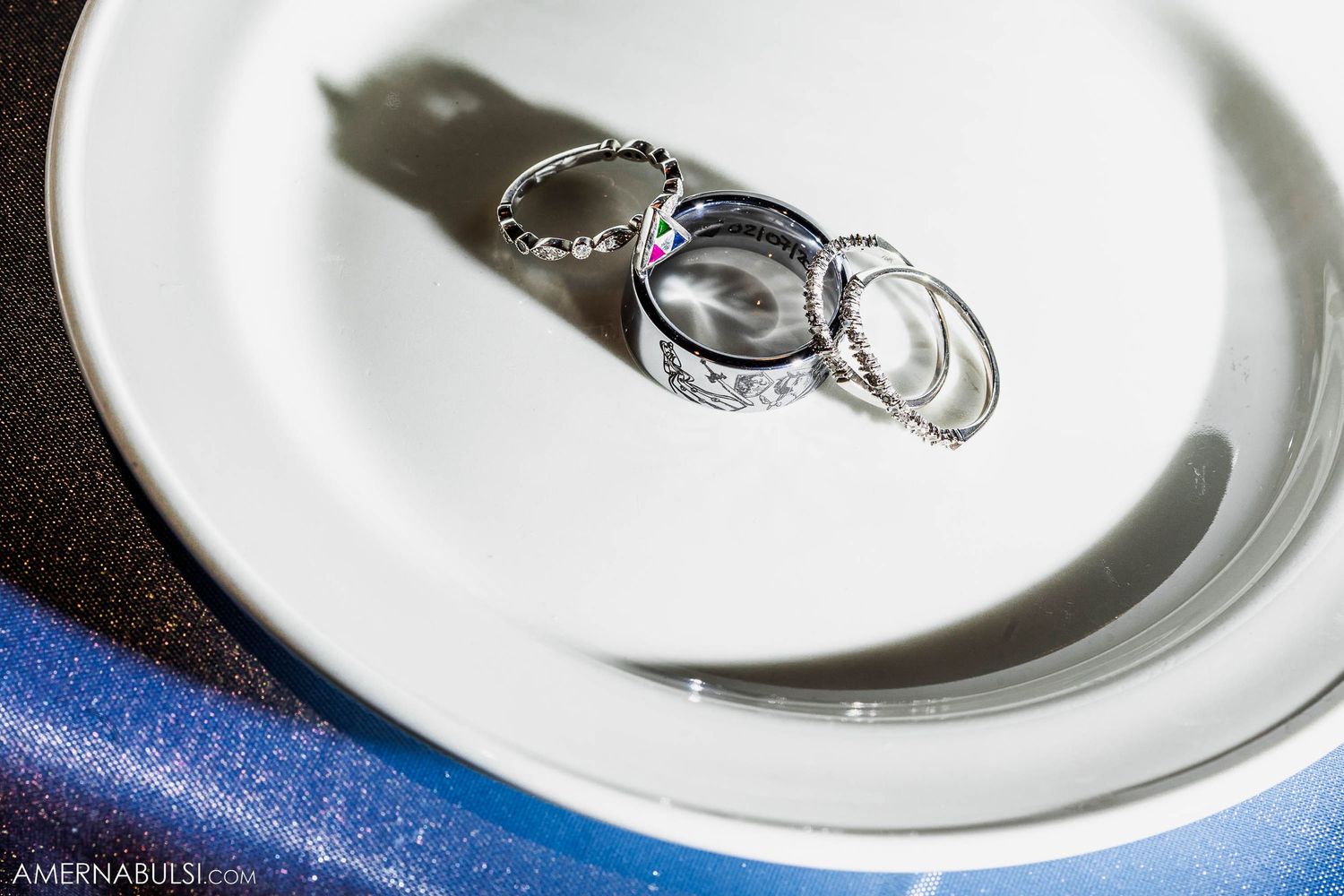 Wedding rings sitting on a white plate in macro photography.