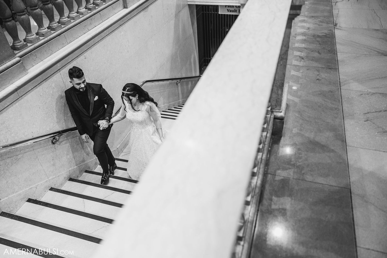 Black and white photo capturing movement on an elegant marble staircase.