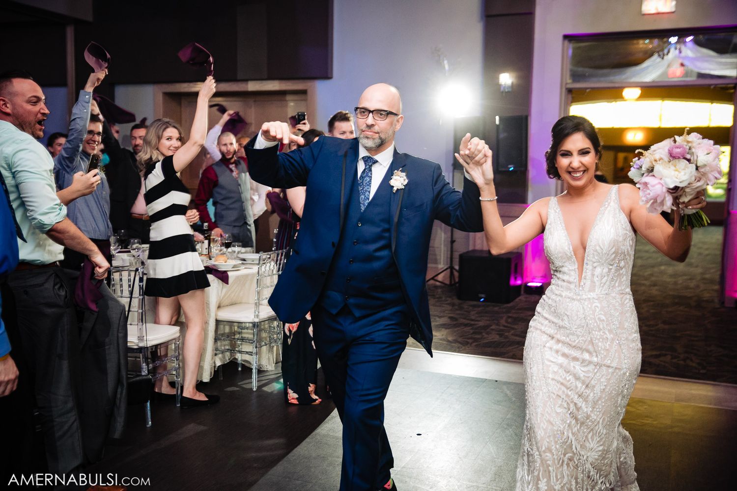 Wedding guests enjoying themselves on a dimly lit dance floor during an evening celebration.