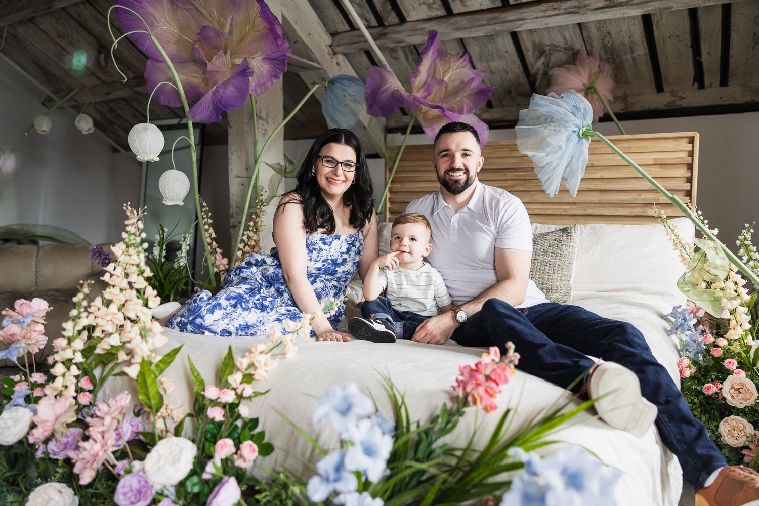 A family photo session with floral decorations and dreamy lighting in a studio setting.