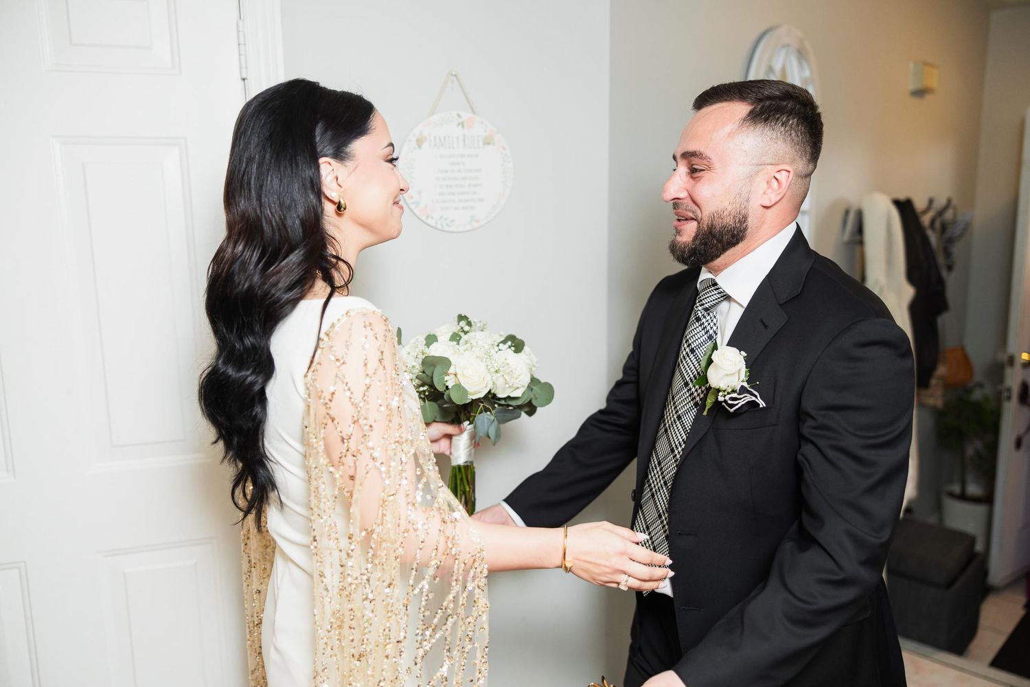 A romantic first look moment between two people in formal attire holding hands.