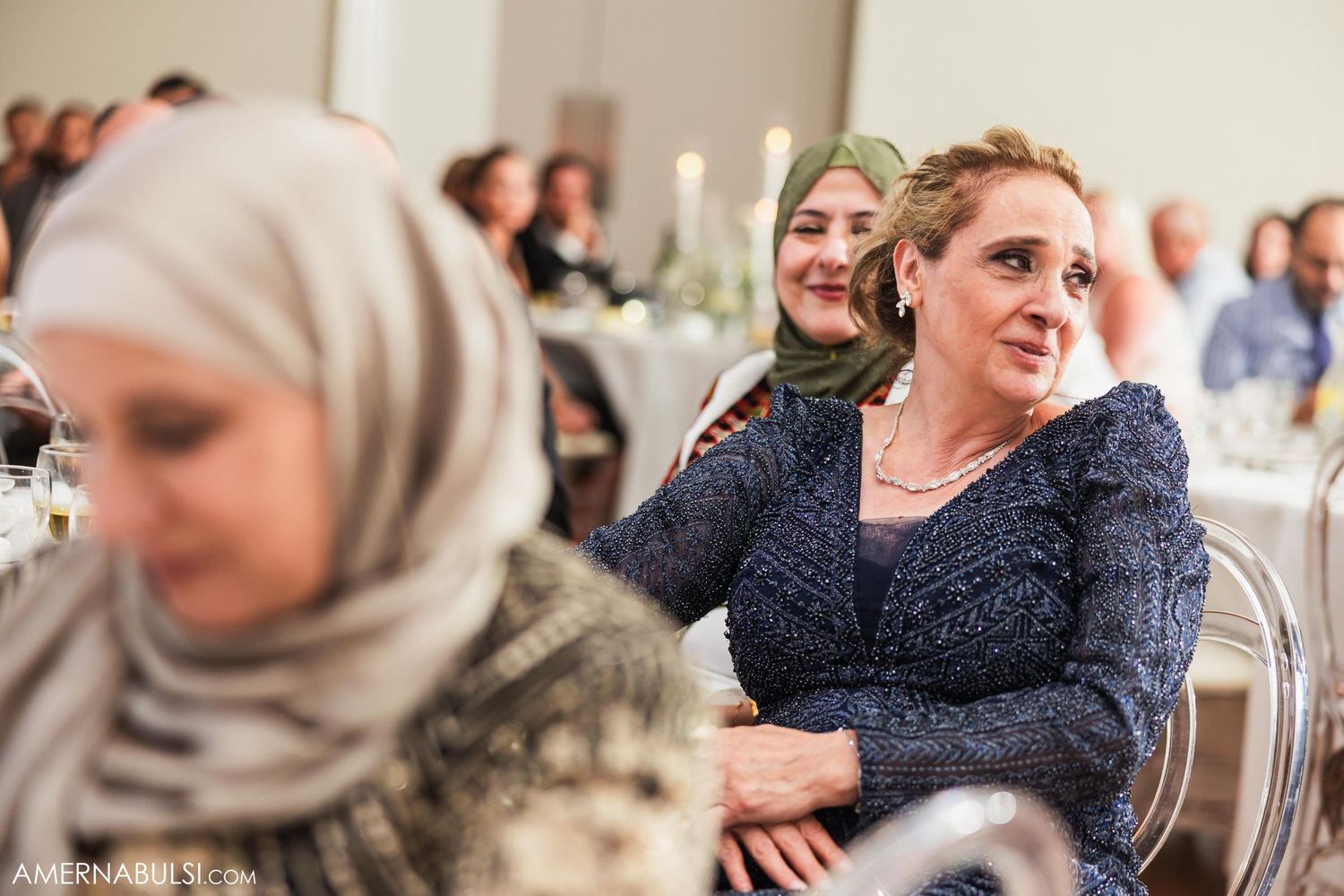 Wedding guests enjoy the reception celebrations in an elegant banquet hall setting.