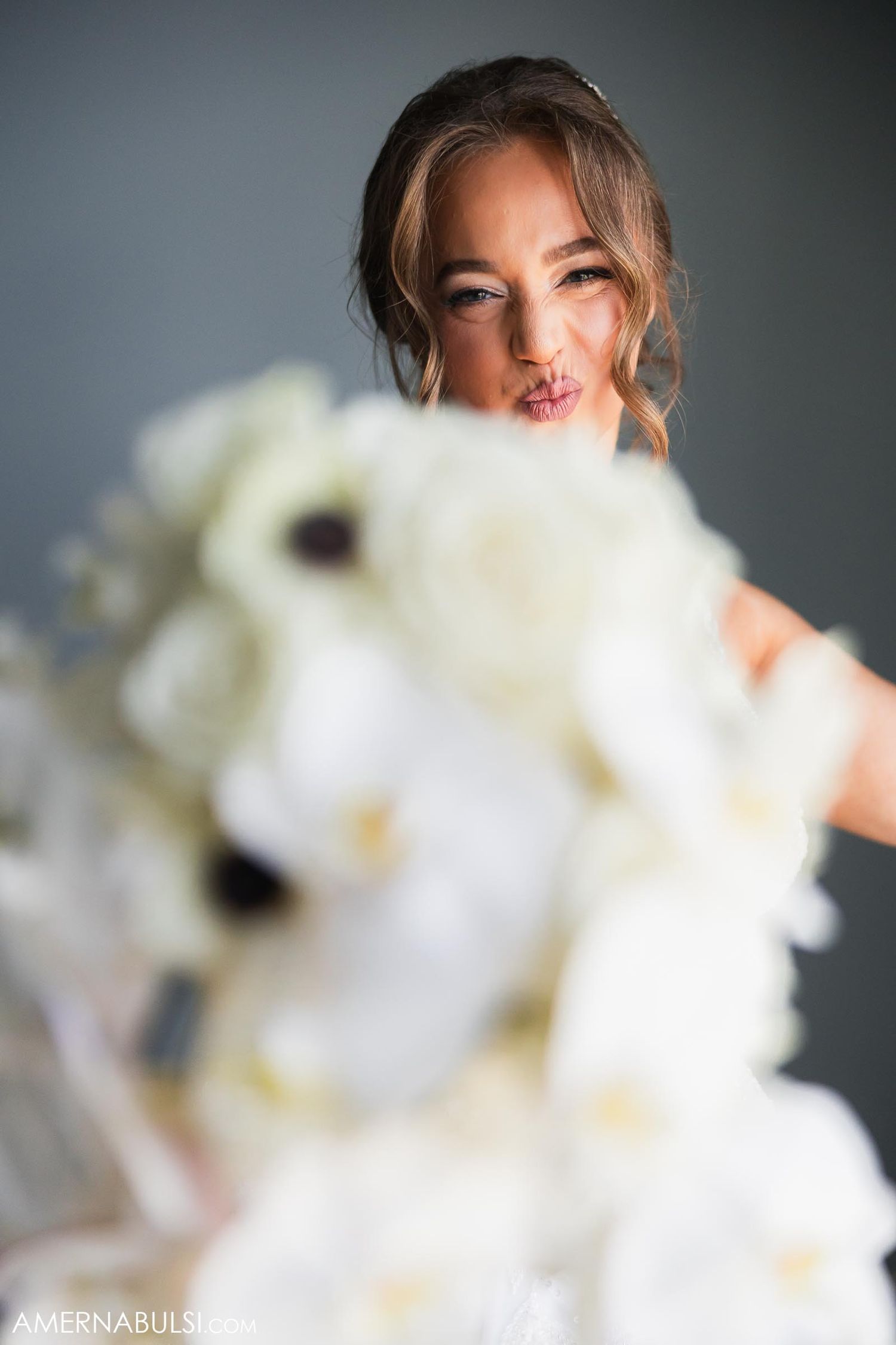 A dreamy bridal portrait with a white floral bouquet in soft focus.