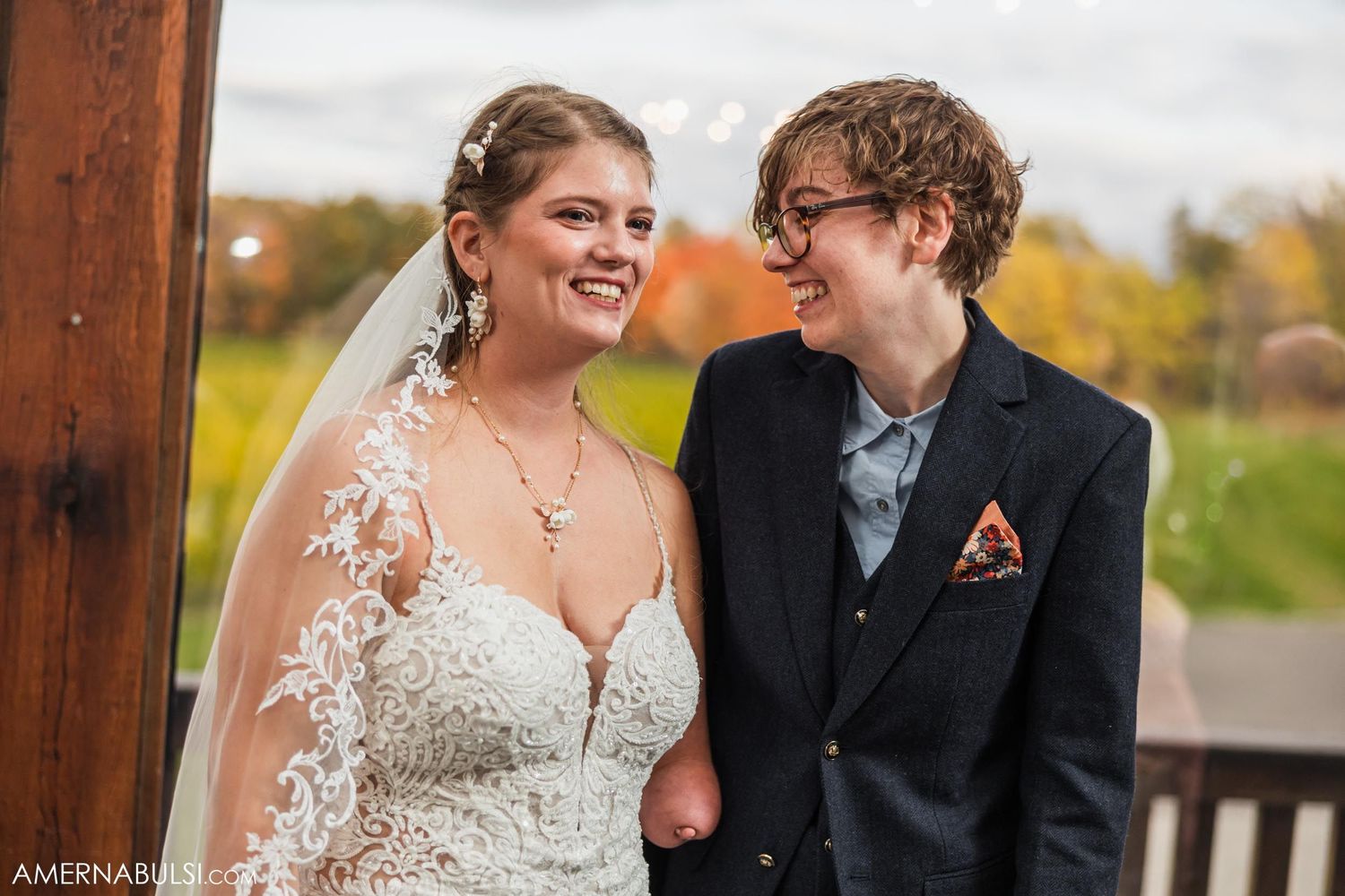 Happy couple shares joyful moment together on outdoor deck with autumn scenery.