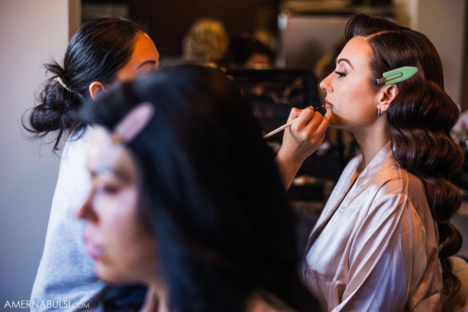 Wedding day makeup preparation scene with artists working on styling.