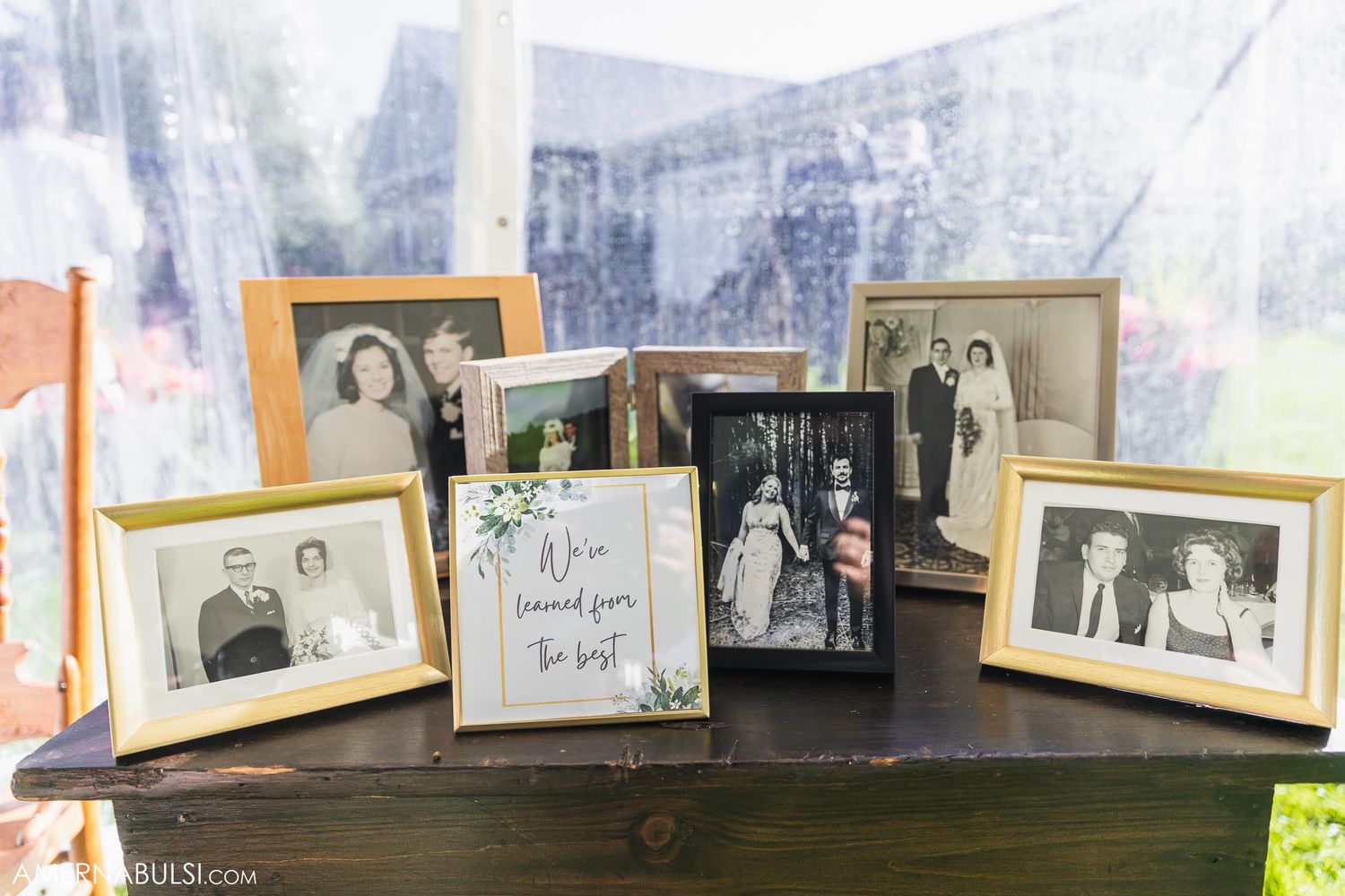 Vintage family wedding photos displayed in frames at reception decor table.