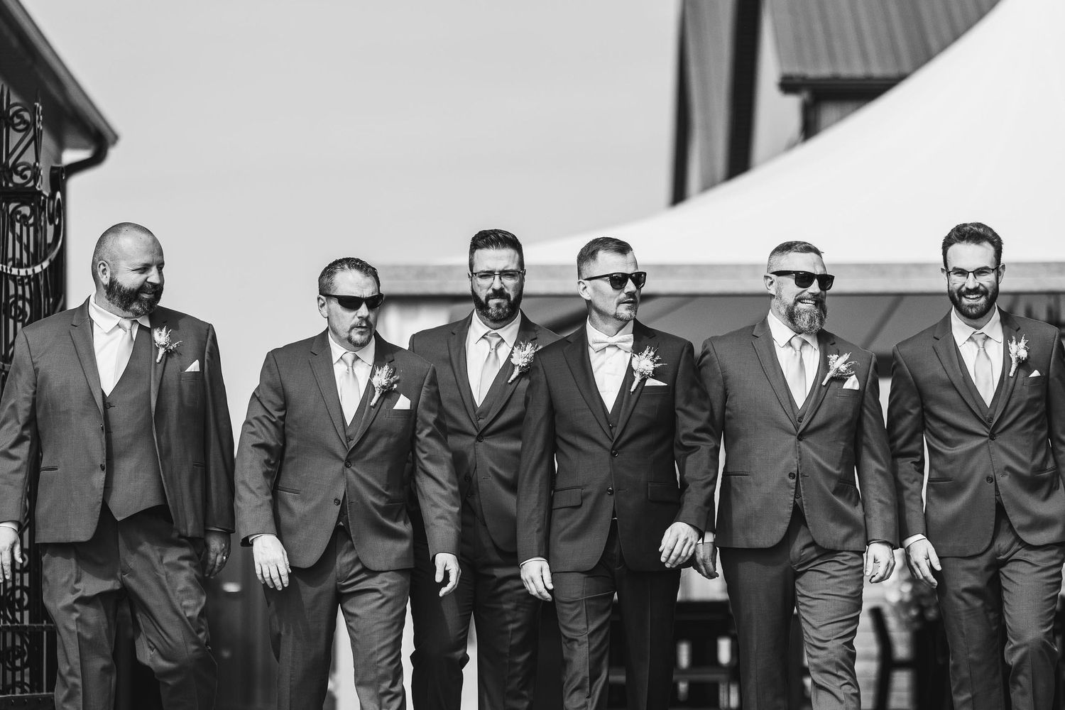 Black and white photo of groomsmen walking together in formal attire.