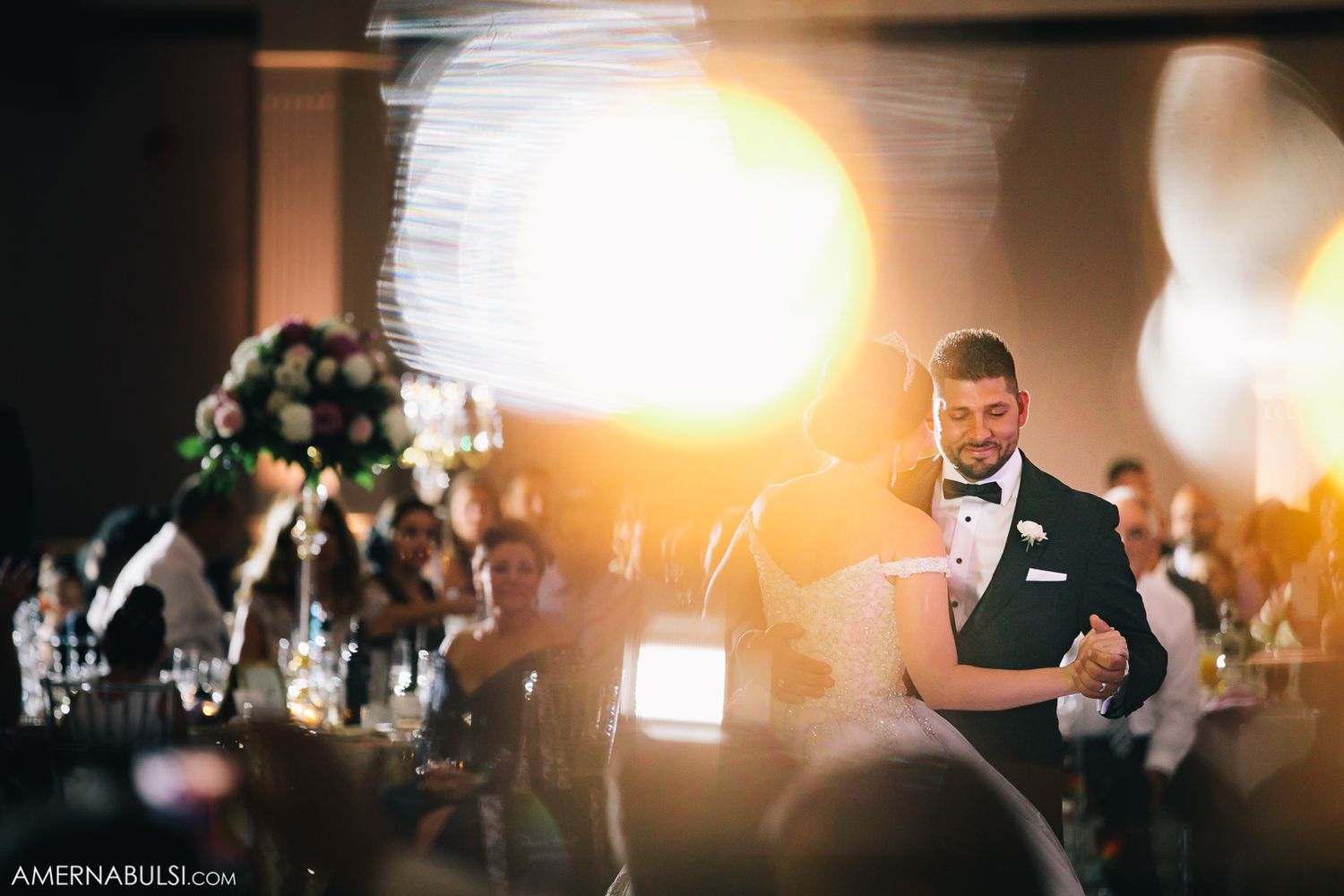 Artistic wedding reception photo with dramatic lighting and bokeh effects.