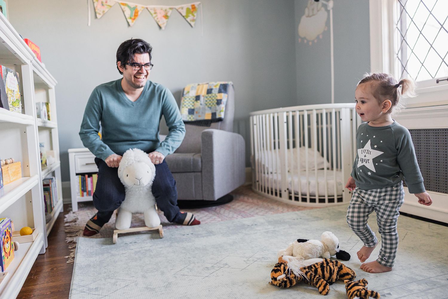 Nursery room with crib, toys, and decorative bunting flags showing modern baby room decor.