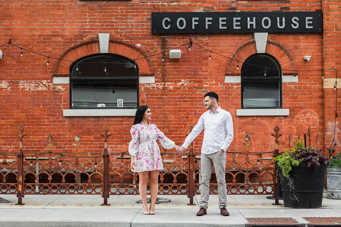 Historic red brick coffeehouse building provides urban backdrop for romantic photos.