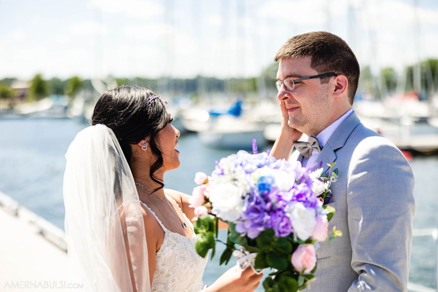 Sunny wedding portrait with purple and pink bouquet at marina dock.