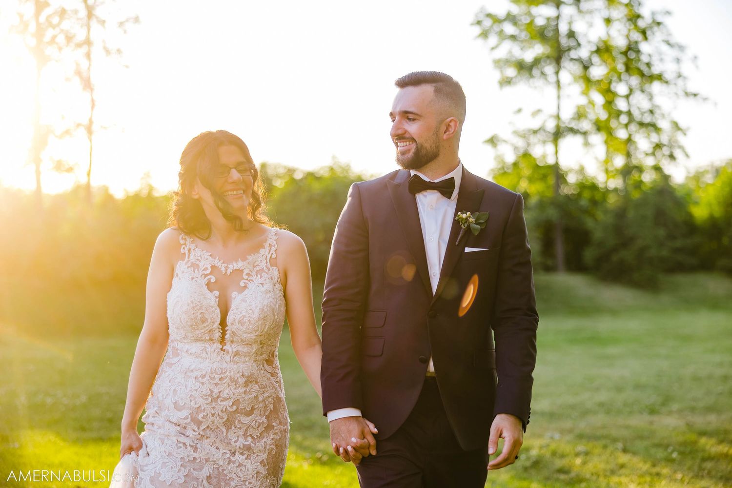 Newlyweds share a joyful moment while walking together during golden hour.