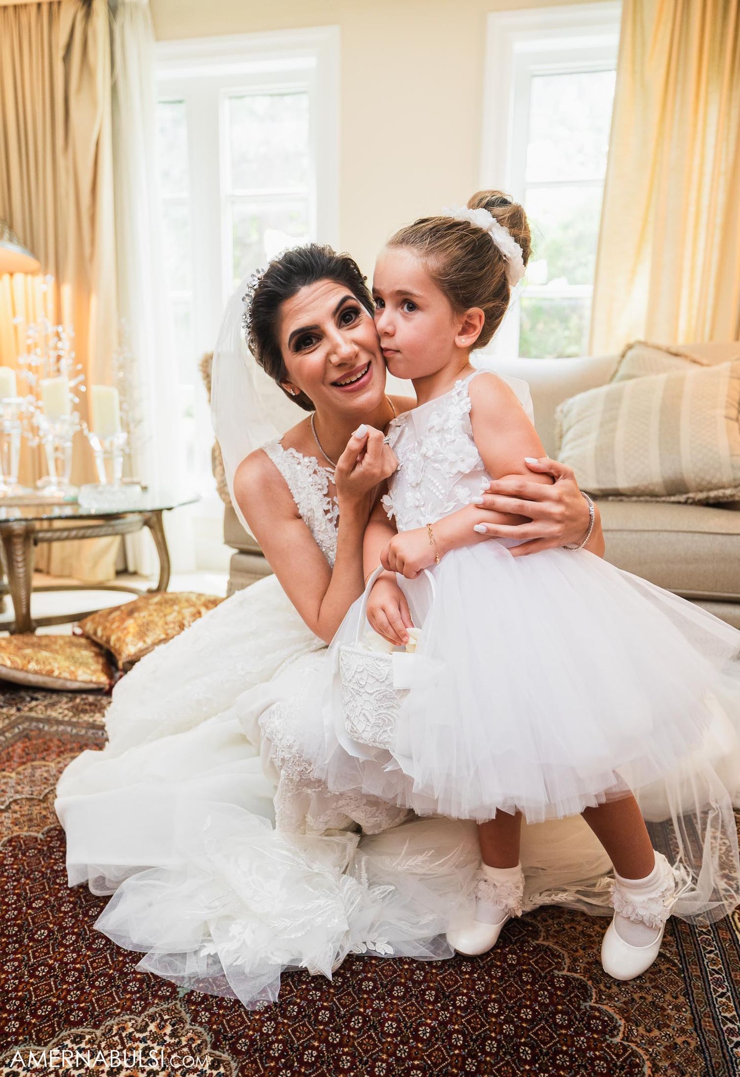 A tender moment between two figures in white dresses during wedding celebrations.