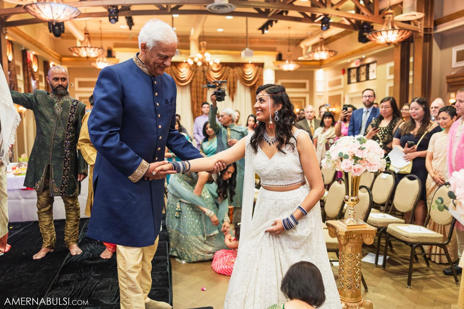 Wedding celebration in elegant ballroom with decorative lighting and formal guest attire.