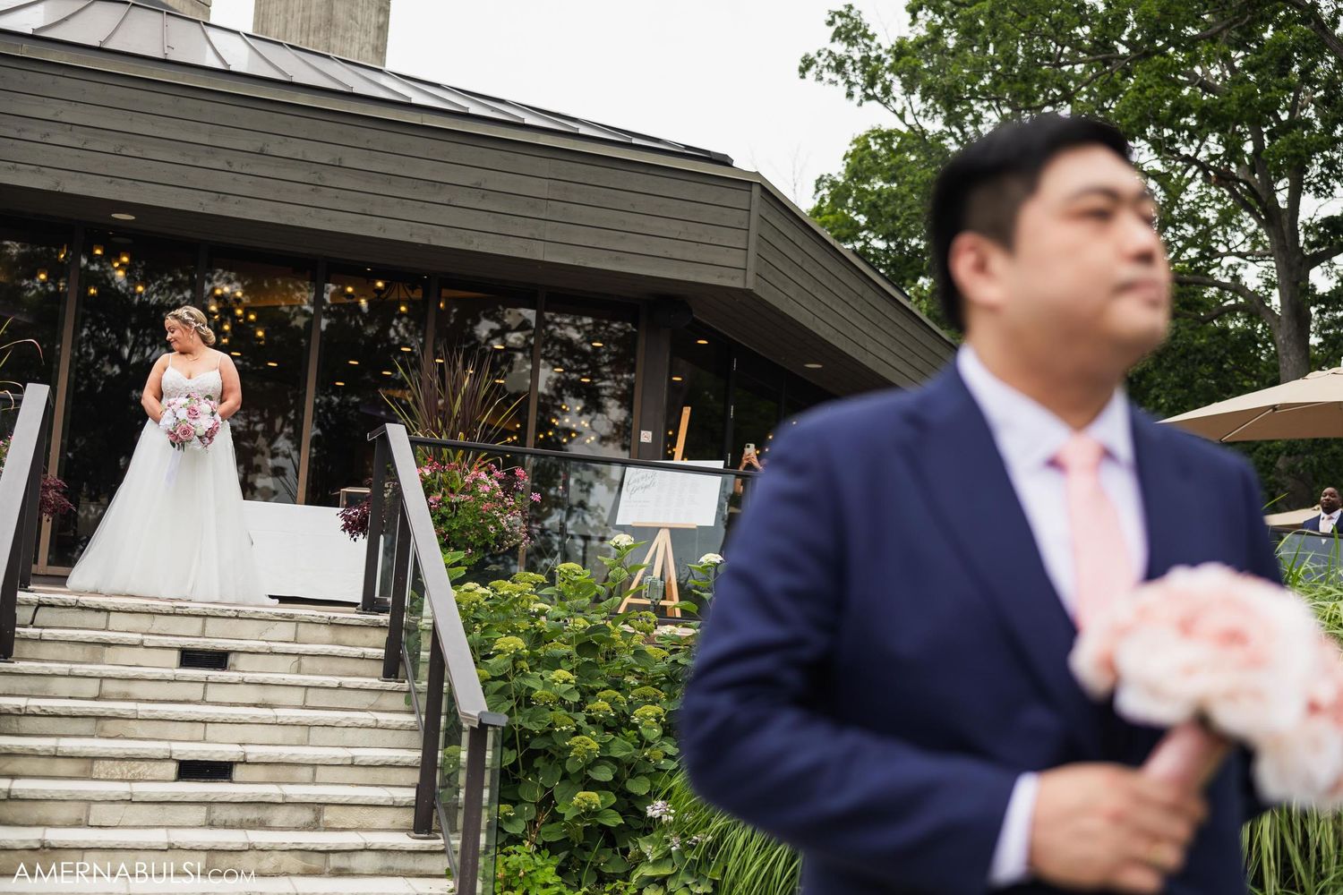 First look wedding moment captured at outdoor venue with stone steps.