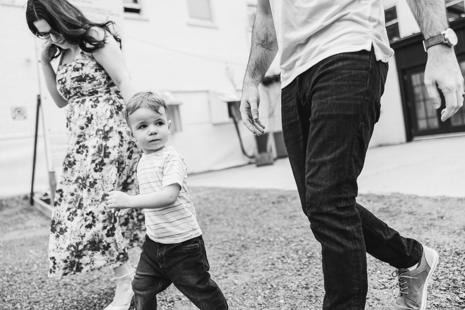 Black and white candid shot of family playing outside building.