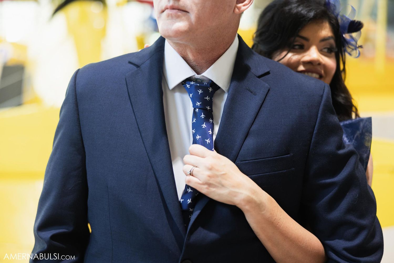 Formal attire detail shot showing navy suit and polka dot tie.