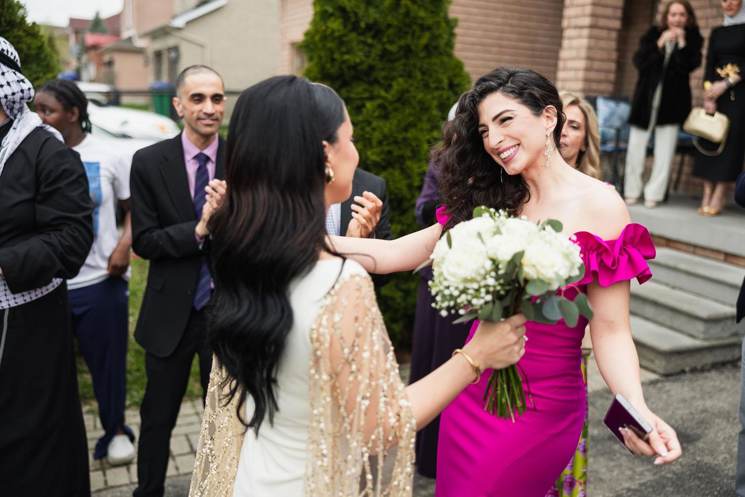 Wedding guests embrace and share joyful moments during an outdoor celebration.