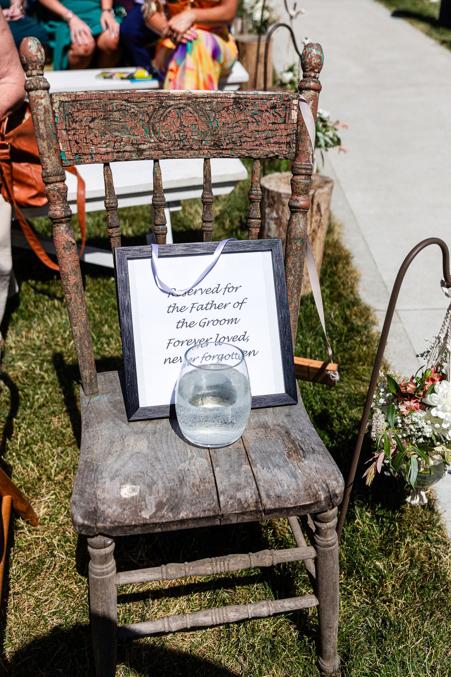 Reserved chair memorial sign for Father of the Groom at outdoor wedding ceremony.