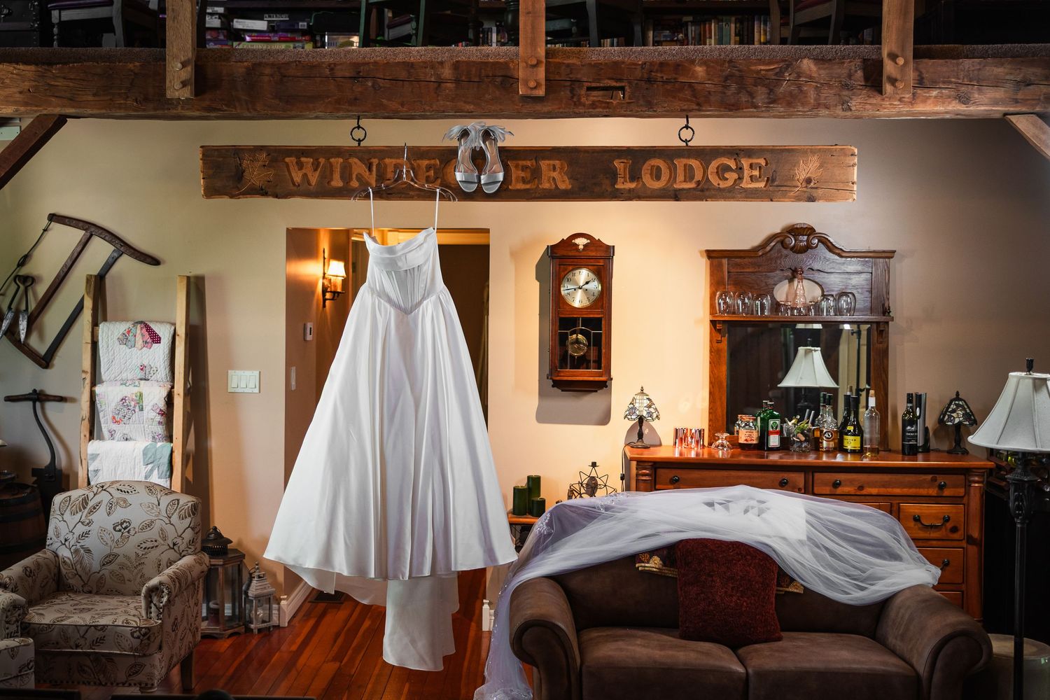 Wedding dress hanging at Windecker Lodge rustic venue with vintage decor and wooden beams.