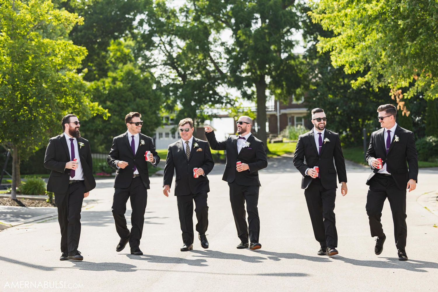 Group of men in black suits walking together outdoors.