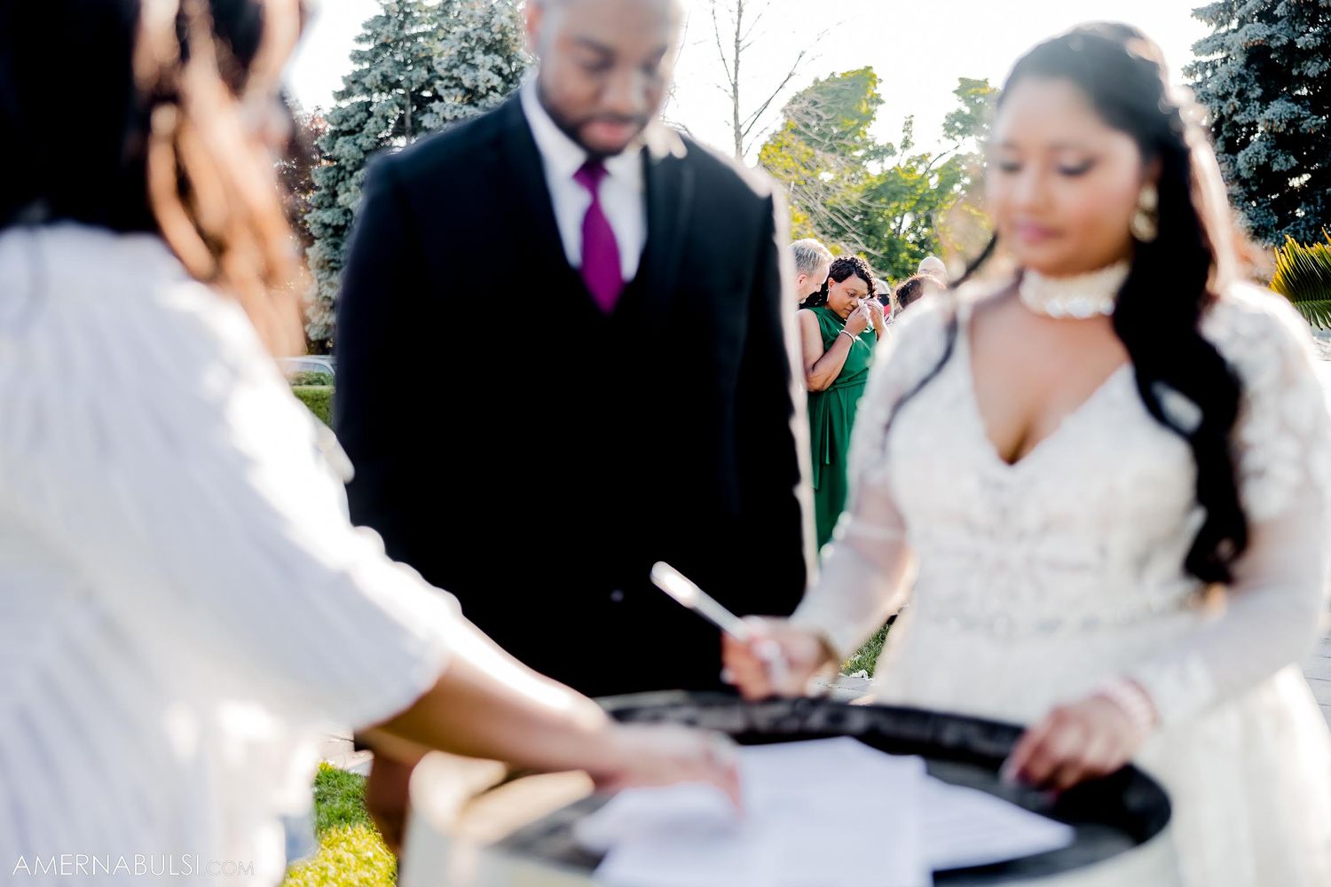 Soft focus shot of wedding ceremony signing moment under sunny skies.