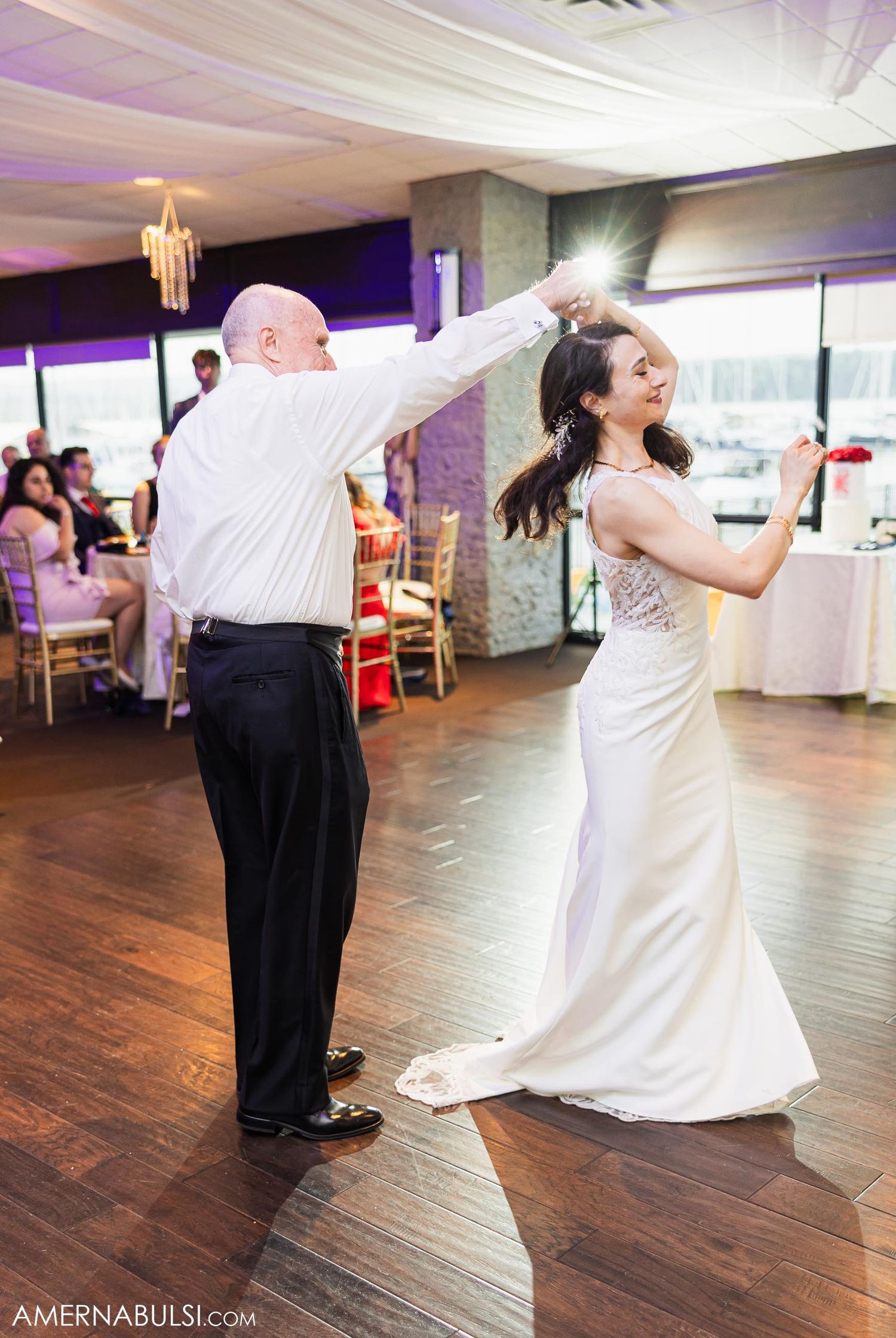 Festive dance moves during father-daughter wedding dance on hardwood floor.