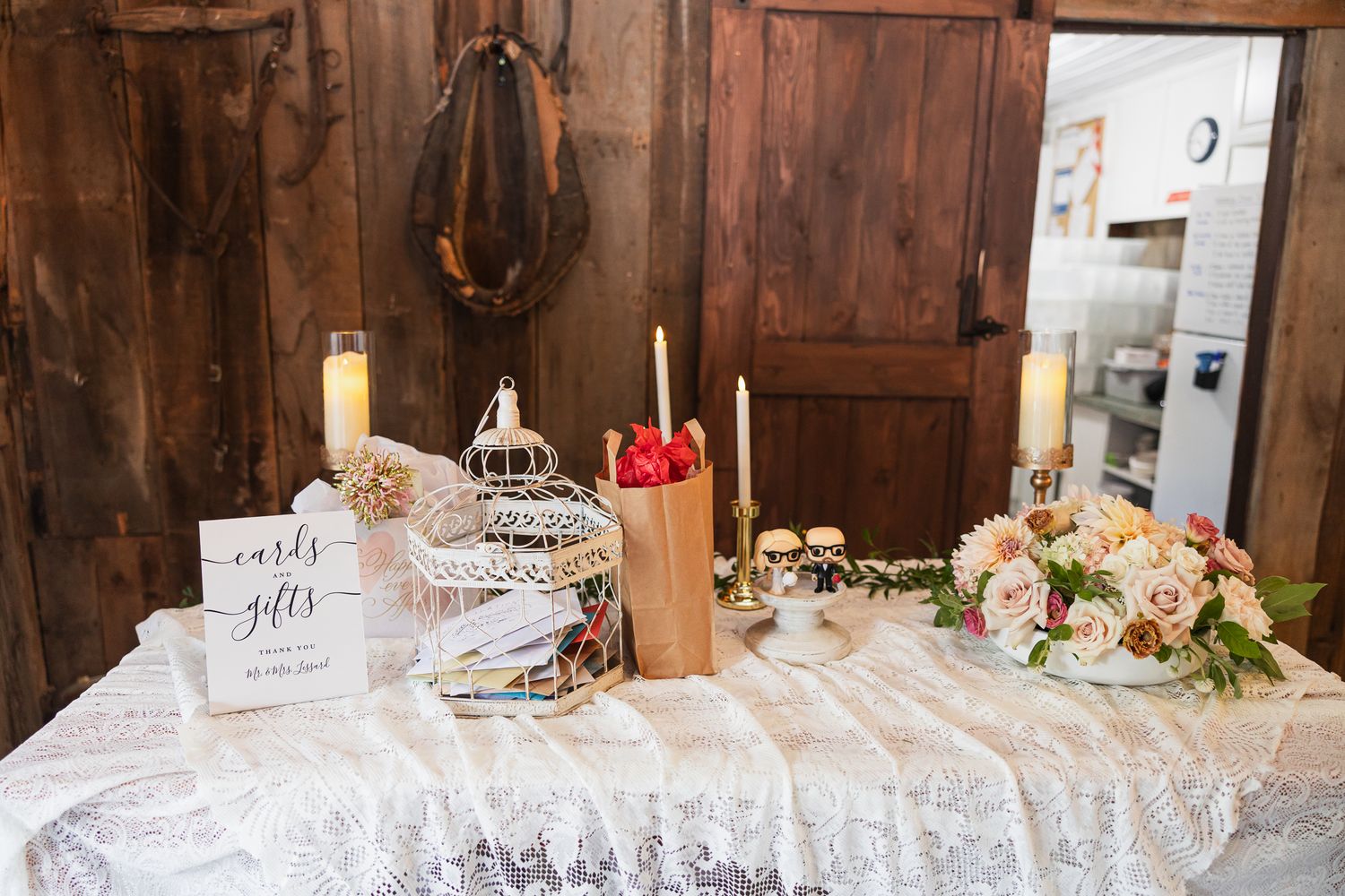 A rustic wooden barn interior decorated with elegant tablescapes and lace details for a wedding reception.