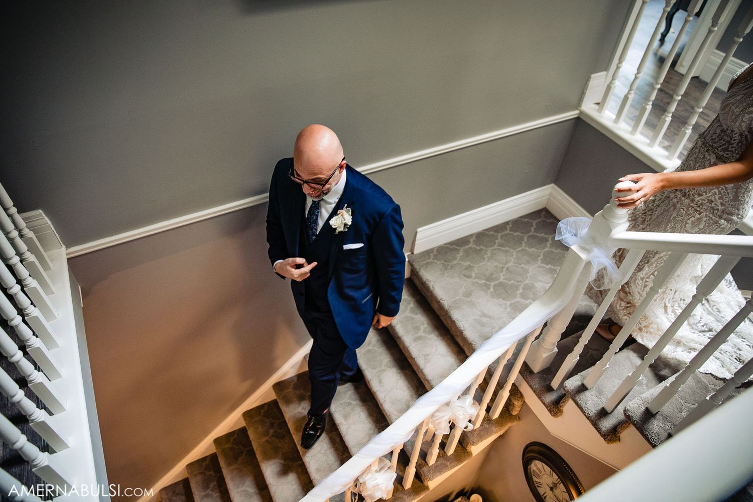 Wedding party members descending a staircase in formal attire.