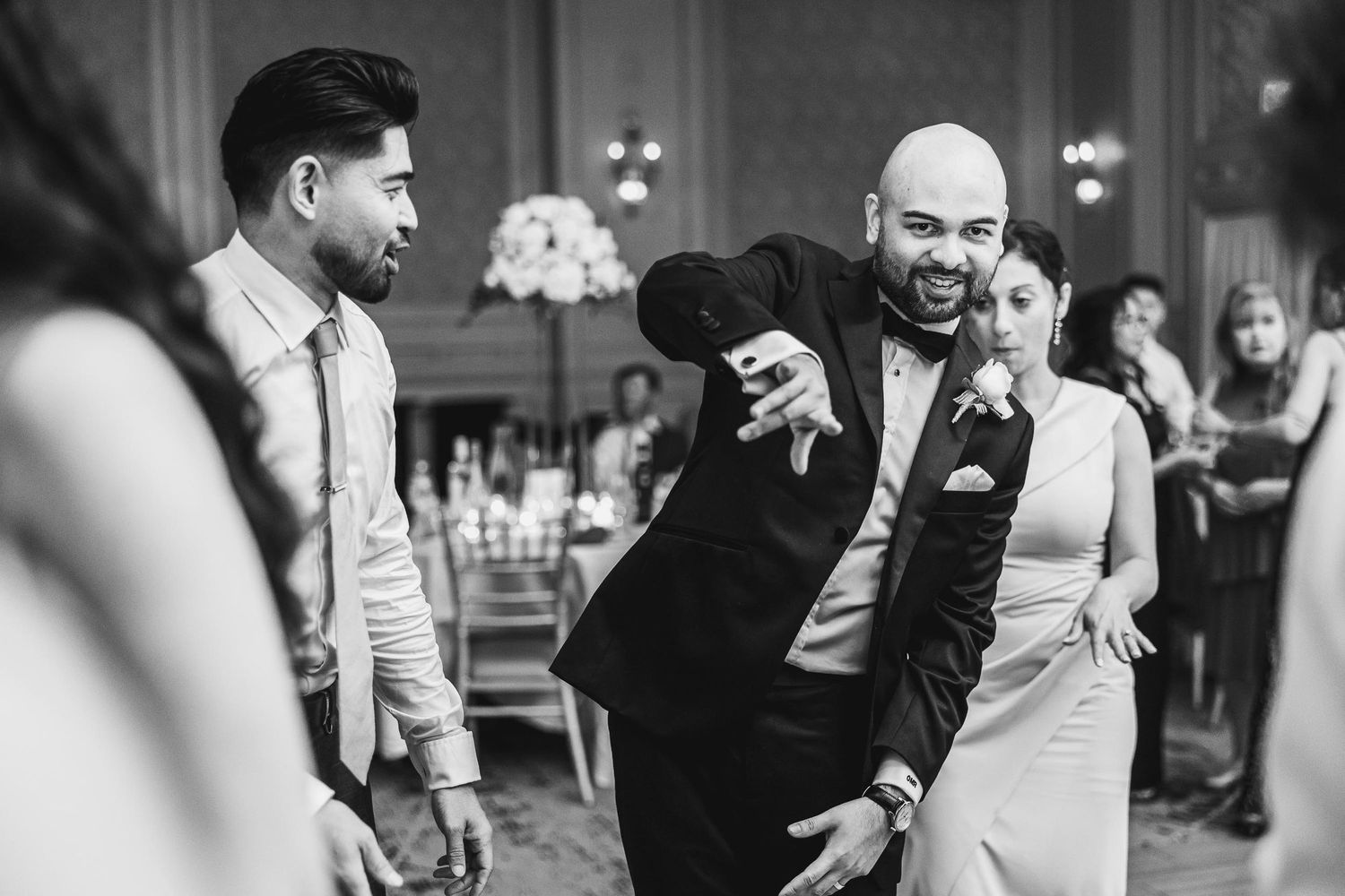 Dance floor excitement captured in black and white during a wedding celebration.