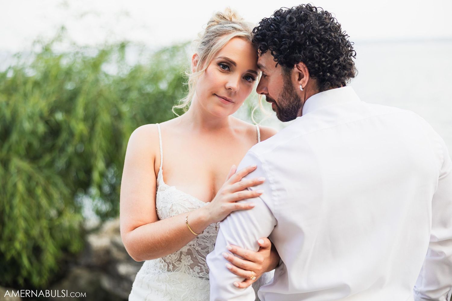 Intimate moment between couple during outdoor wedding portraits.
